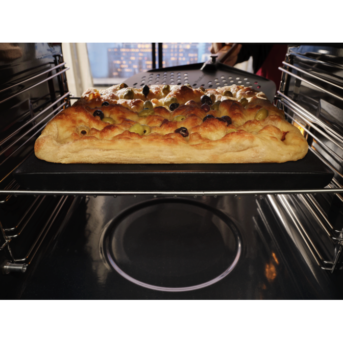 Focaccia baked inside oven taken out with pizza peel 