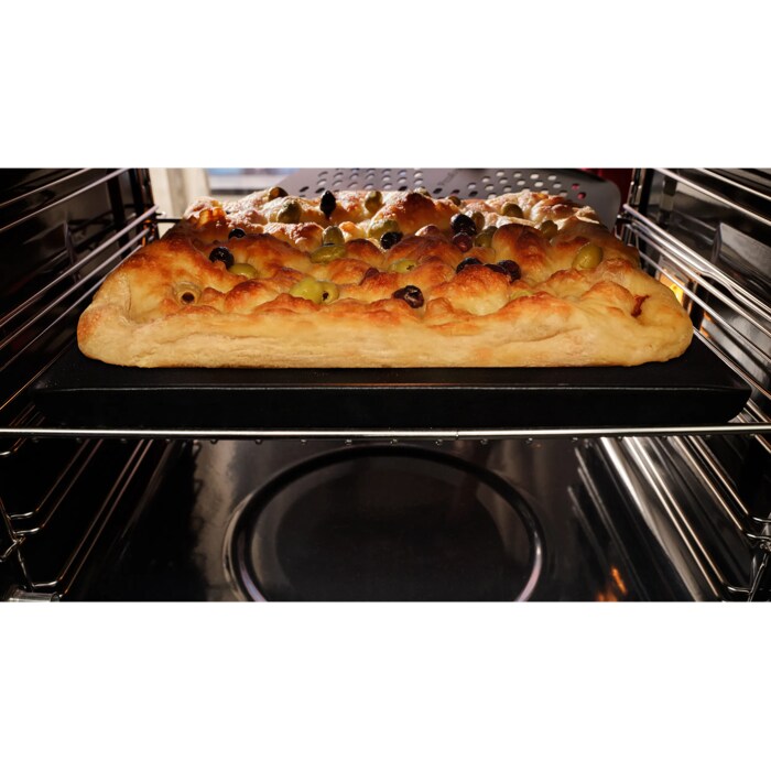 Focaccia baked inside oven taken out with pizza peel 