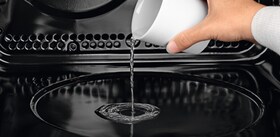 Versare dell'acqua nel forno a vapore multifunzione PlusSteam