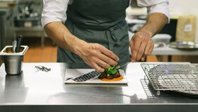 Chef che impiatta delle delizie prelibate presentate in modo impeccabile